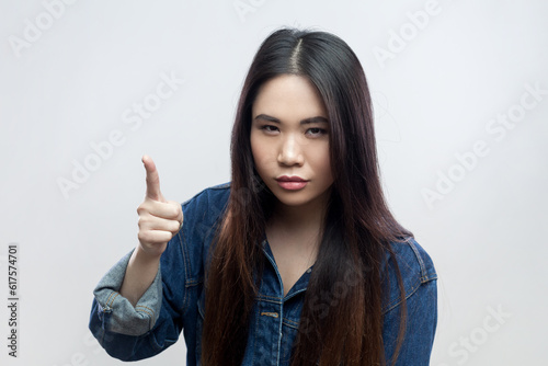 Φωτογραφία Portrait of serious beautiful brunette woman in blue denim jacket standing with raised finger, warning you, looking at camera with strict expression