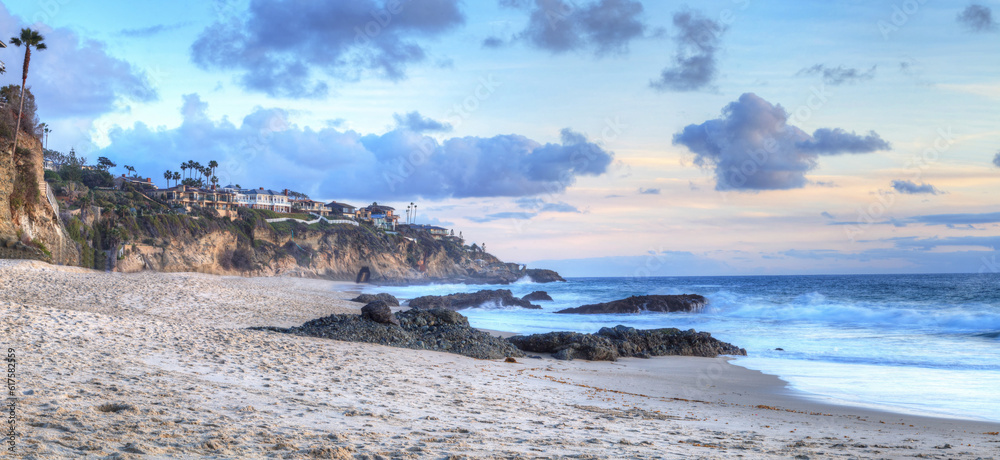 Sunset over the coastline of One Thousand Steps Beach with tidal pools and cliffs in Laguna Beach, California, USA
