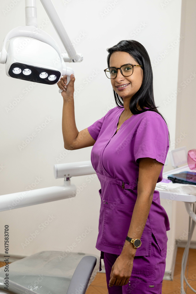 interior of dental office with female dentist with straight hair wears glasses and comfortable purple uniform, health professions, woman smiling interior of dental office with female dentist with straight hair wears glasses and comfortable purple uniform, health professions, woman smiling