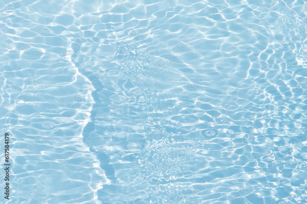 Fototapeta premium Blue water with ripples on the surface. Defocus blurred transparent blue colored clear calm water surface texture with splashes and bubbles. Water waves with shining pattern texture background.