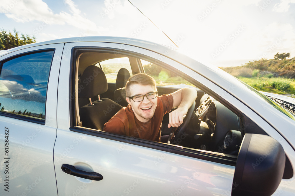 Attractive young man showing his new car keys and smiling.