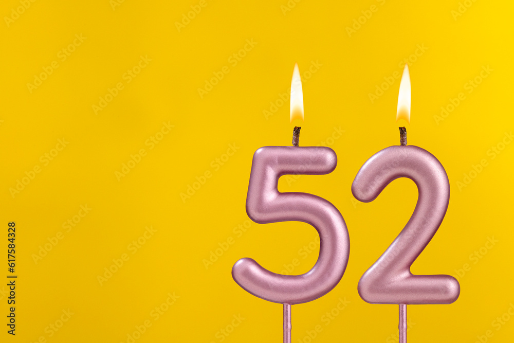 Birthday candle number 52 - Birthday celebration on yellow background Birthday candle number 52 - Birthday celebration on yellow background