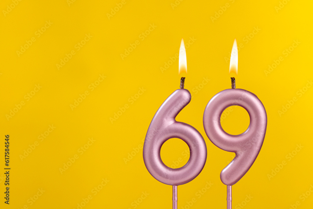 Candle 69 with flame - Birthday card on yellow luxury background Candle 69 with flame - Birthday card on yellow luxury background
