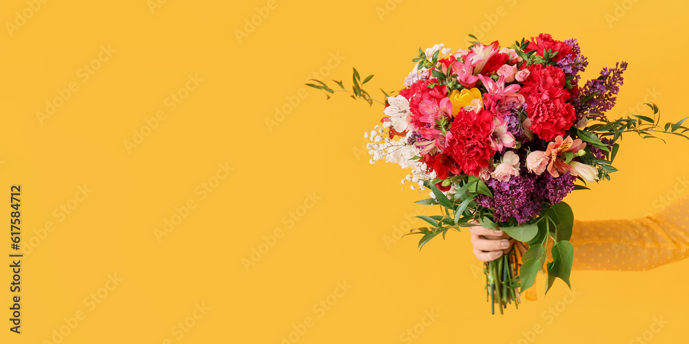 Obraz premium Female hand with beautiful bouquet on yellow background with space for text