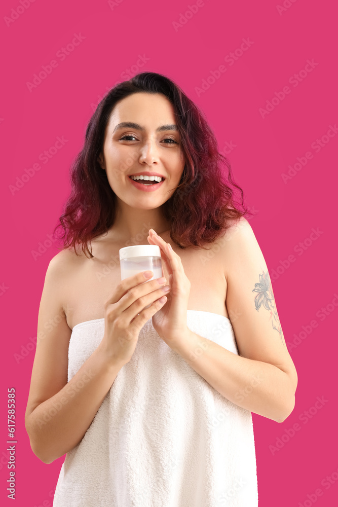 Young brunette woman with jar of cosmetic cream on pink background Young brunette woman with jar of cosmetic cream on pink background