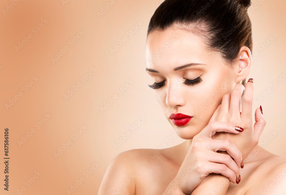 beautiful woman with dark makeup and red lipstick posing on light beige background