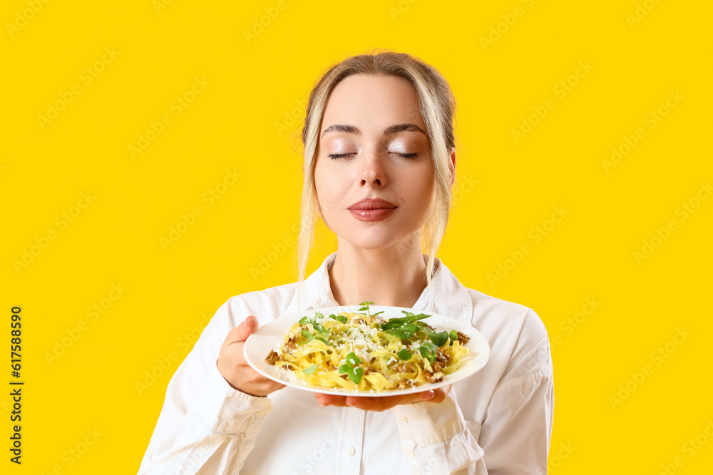 Young woman with tasty pasta on yellow background, closeup Young woman with tasty pasta on yellow background, closeup