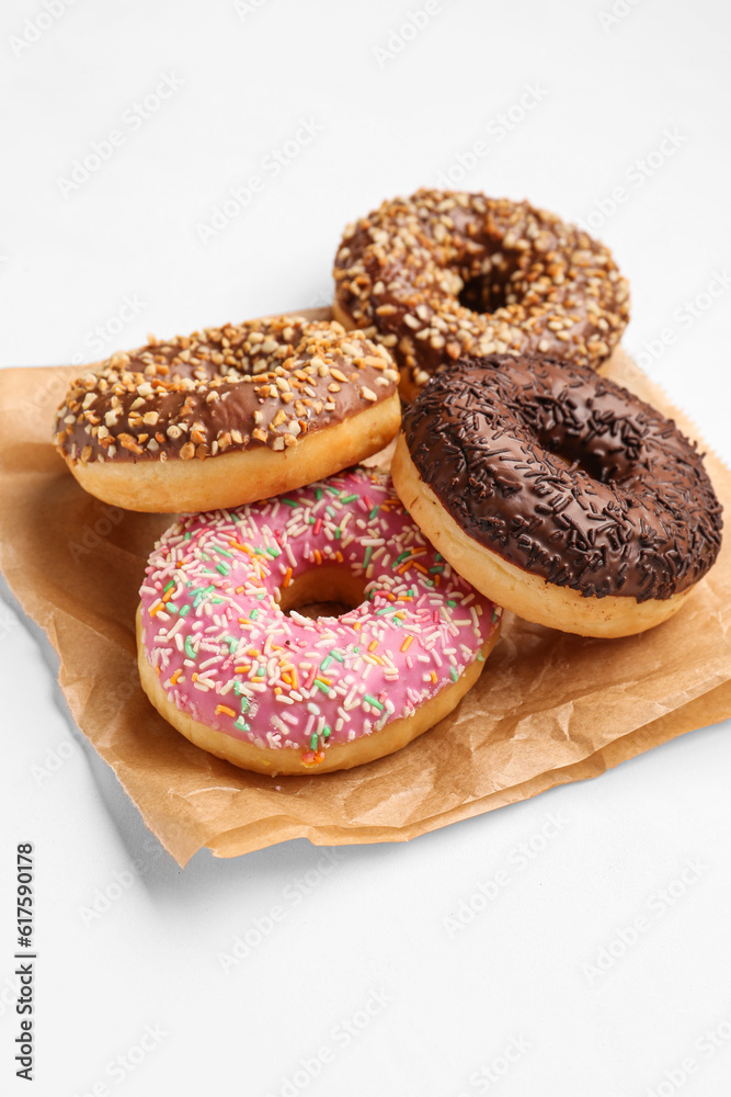 Paper bag with sweet donuts on white background