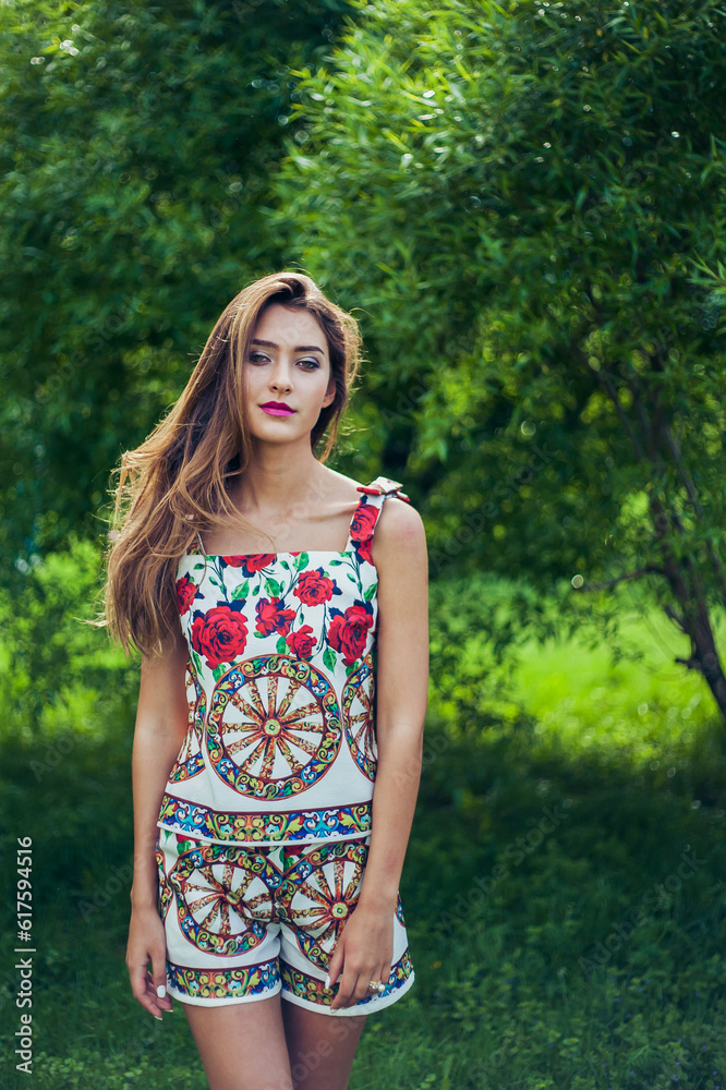 Portrait of young beautiful woman wearing trendy summer outfit posing in park. Professional make-up and hairstyle. Perfect skin. Fashion photo. Portrait of young beautiful woman wearing trendy summer outfit posing in park. Professional make-up and hairstyle. Perfect skin. Fashion photo.