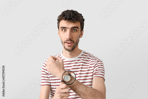 Shocked young man magnifyin...