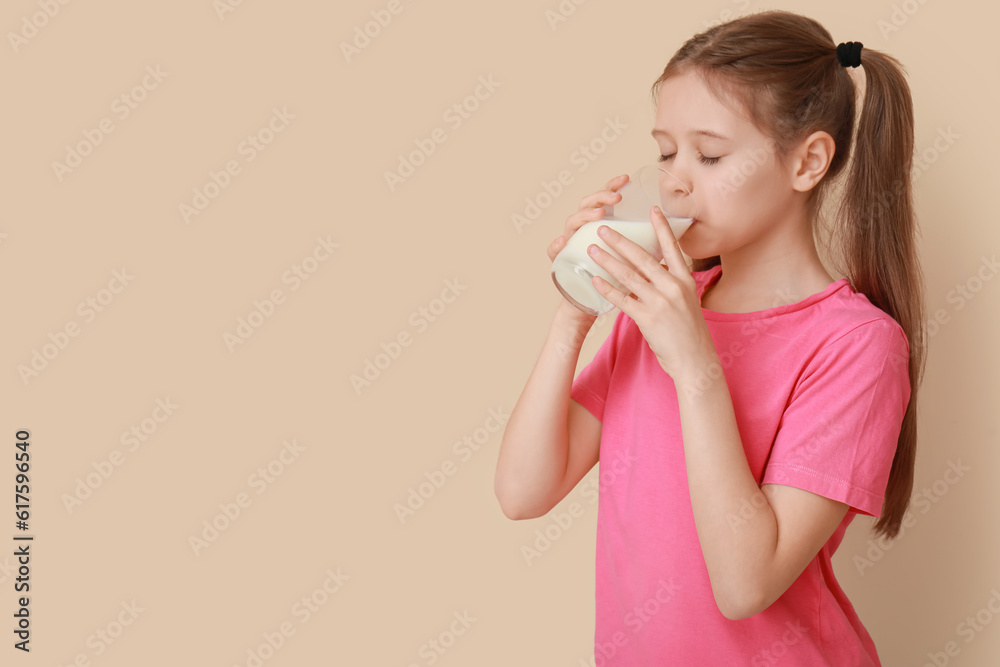 Little girl drinking milk on beige background Little girl drinking milk on beige background