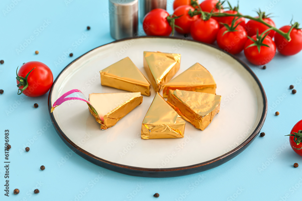 Plate with triangles of tasty processed cheese on blue background Plate with triangles of tasty processed cheese on blue background