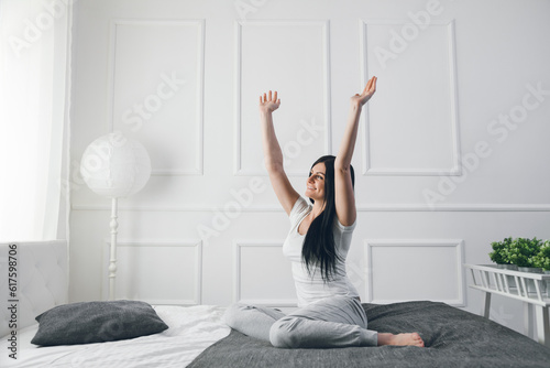 Beautiful young woman relaxing on the bed in the morning