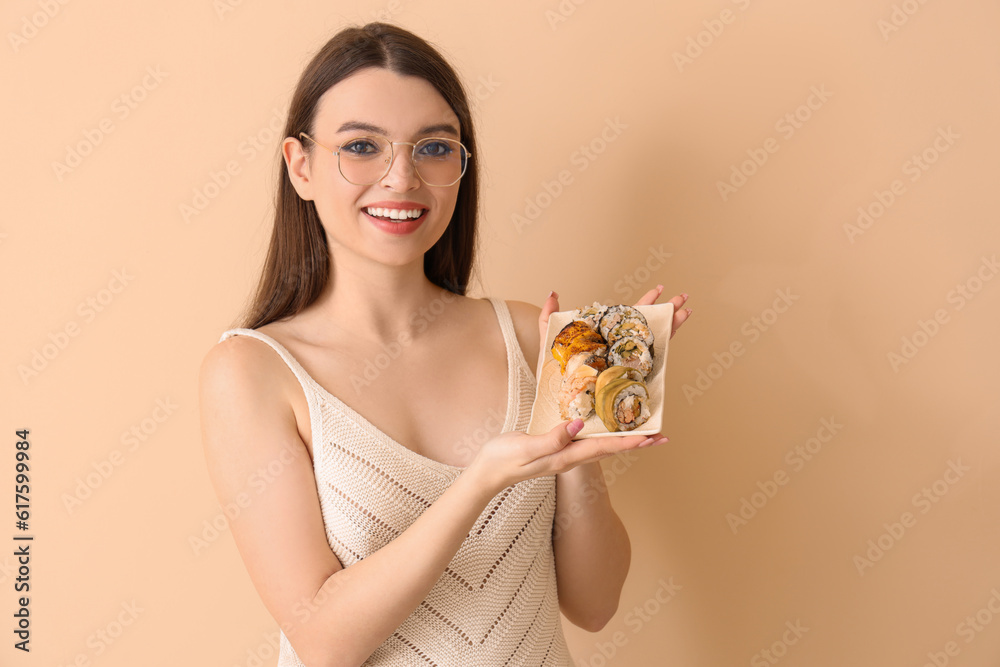 Young woman with sushi on beige background Young woman with sushi on beige background