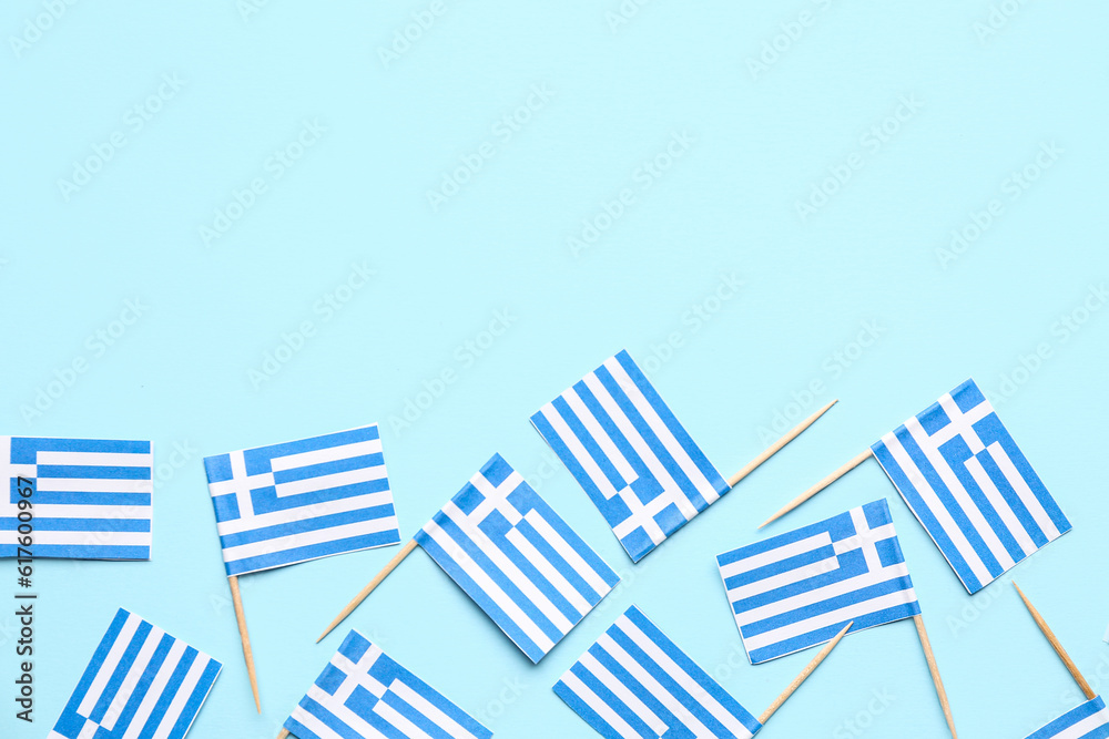 Many paper flags of Greece on blue background Many paper flags of Greece on blue background