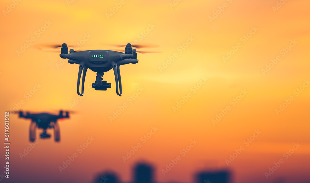Two Professional Remote Control Air Drones with action camera flying in dramatic sunset sky. Modern technologies. Travel, hobby, inspiration. Pastel orange toning. Horizontal copy space. Kiev, Ukraine Two Professional Remote Control Air Drones with action camera flying in dramatic sunset sky. Modern technologies. Travel, hobby, inspiration. Pastel orange toning. Horizontal copy space. Kiev, Ukraine