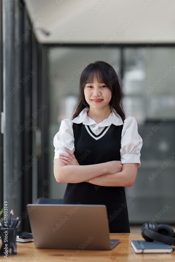 Online education, e-learning. Asian woman in stylish casual clothes, studying using a laptop, listening to online lecture, taking notes, online study at home Online education, e-learning. Asian woman in stylish casual clothes, studying using a laptop, listening to online lecture, taking notes, online study at home
