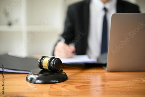 Close-up image of a judge gavel or judge hammer is on a wooden desk in a lawyer office.