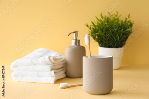 Bamboo tooth brush in holder and toiletries on beige background