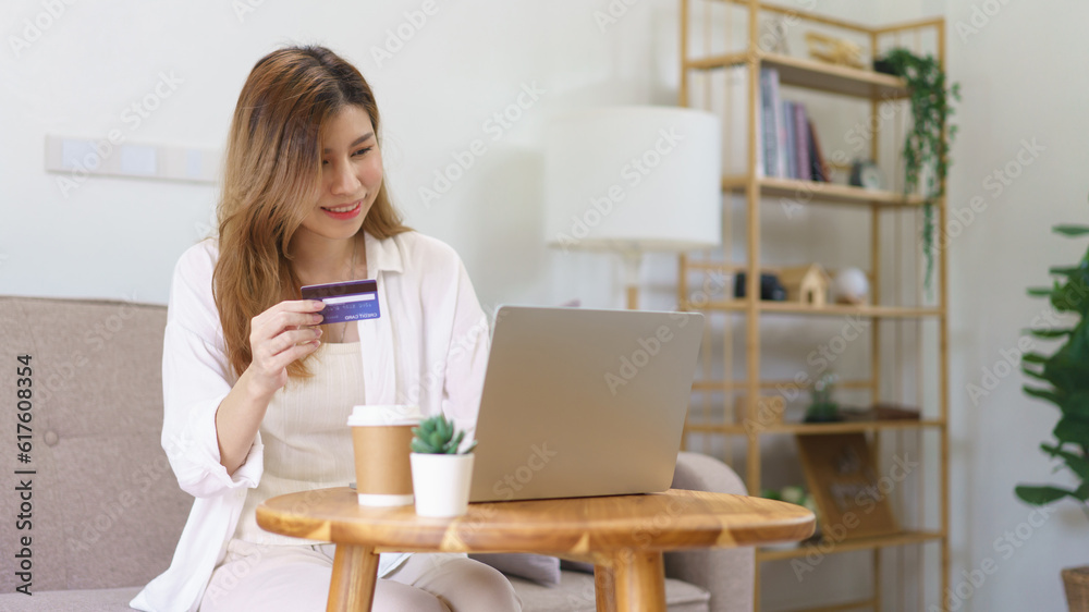 Work from home concept, Businesswoman is typing credit card data on laptop to shopping online Work from home concept, Businesswoman is typing credit card data on laptop to shopping online