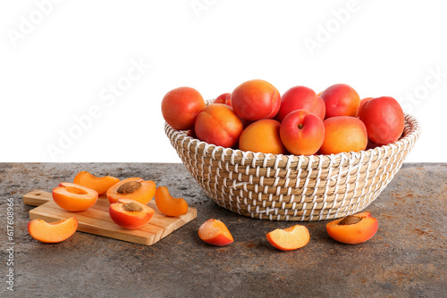 Fototapeta Naklejka Na Ścianę i Meble -  Wicker basket with ripe apricots on table against white background