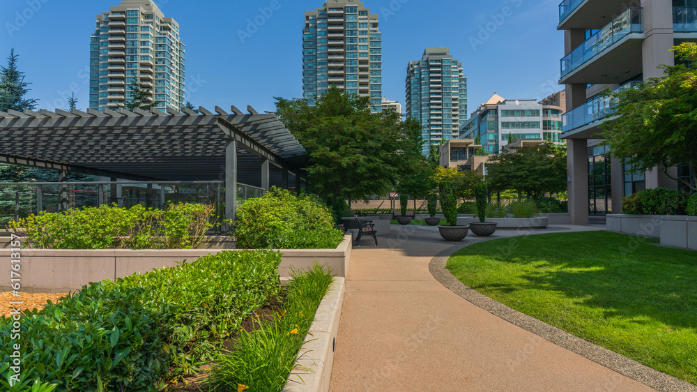 High-rise residential buildings overlooking the calm of an urban garden in Burnaby, BC, Canada.
