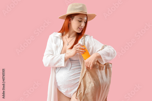 Young pregnant woman puttin...