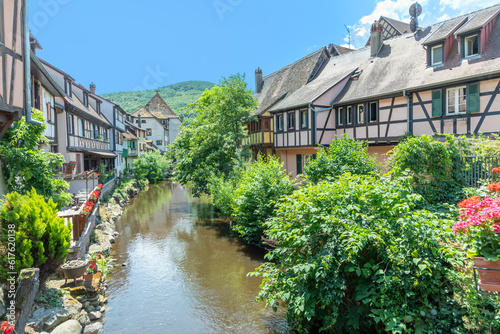 A picturesque colorful view of half-timber buildings at a small creek in the village of Kaysersberg in Vosces region.