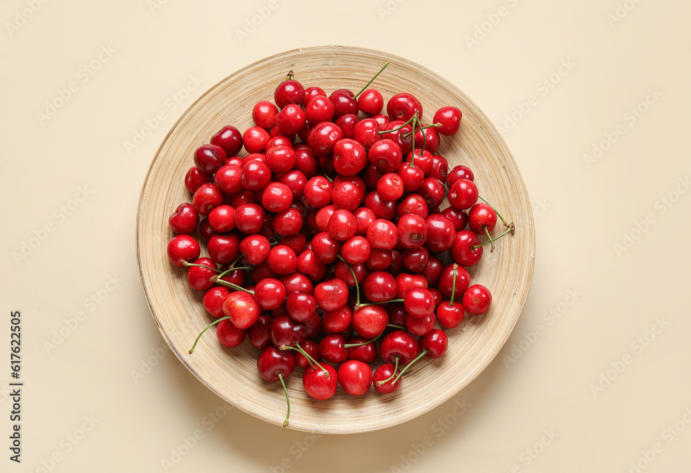 Plate with sweet cherries on beige background Plate with sweet cherries on beige background