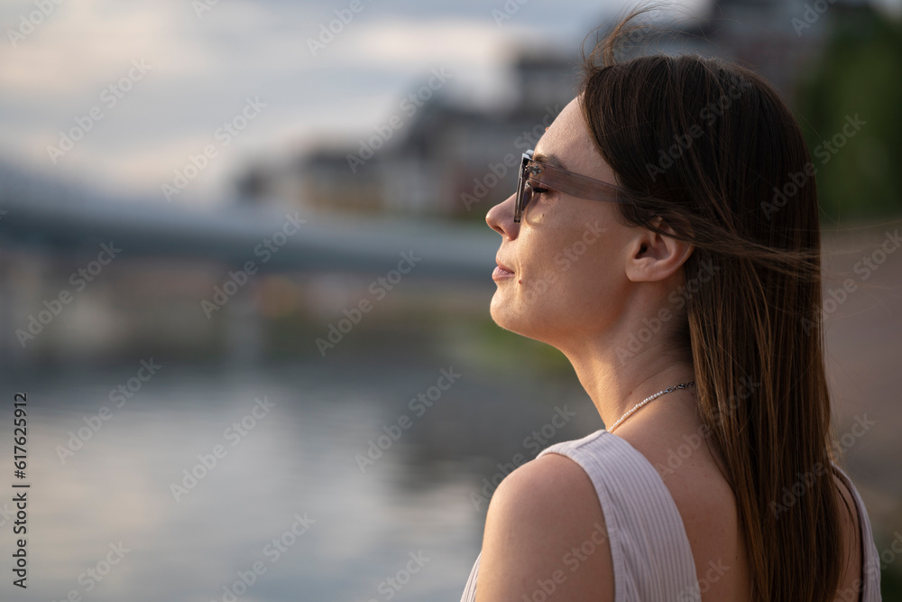 Summer urban portrait of a young brunette woman in sunglasses. Summer urban portrait of a young brunette woman in sunglasses.