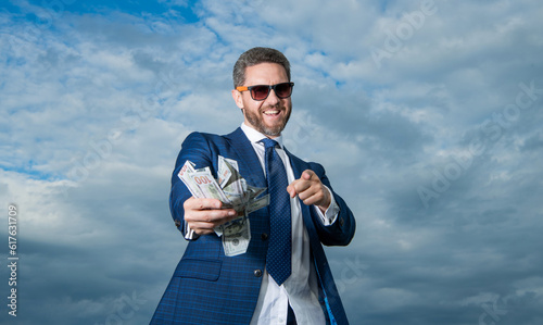 rich millionaire man with money pointing finger on sky background. rich millionaire man photo