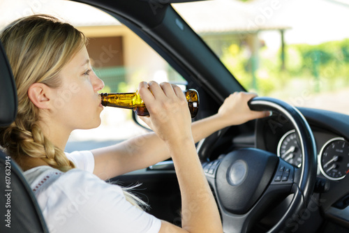 profile of a unconscience woman driving and drinking beer © auremar