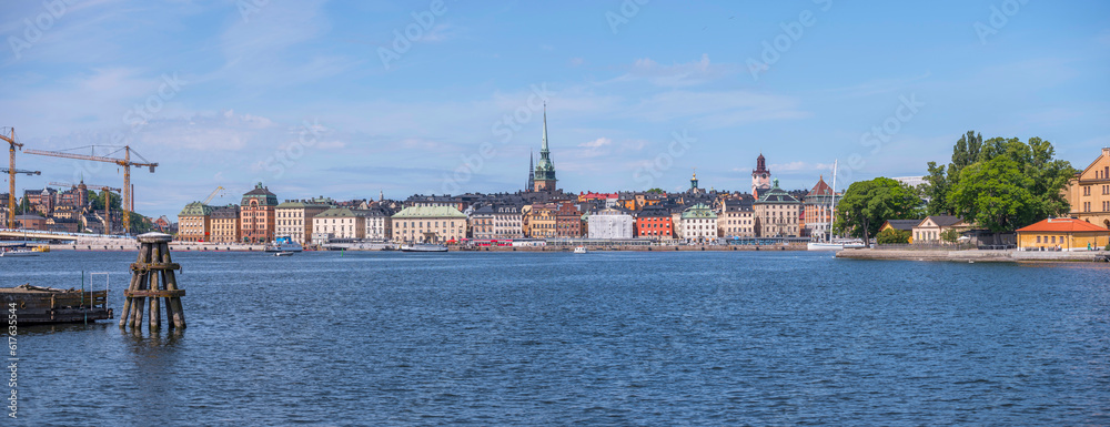 Panorama, view over the old town Gamla Stan, anchor dolphin buoy and platform in the bay Strömmen, a sunny summer morning in Stockholm
