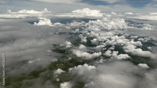 Fliying over clouds and green terrain