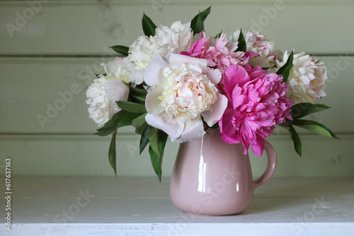 Fototapeta Naklejka Na Ścianę i Meble -  A bouquet of pink and white peonies on the table in a rural house.