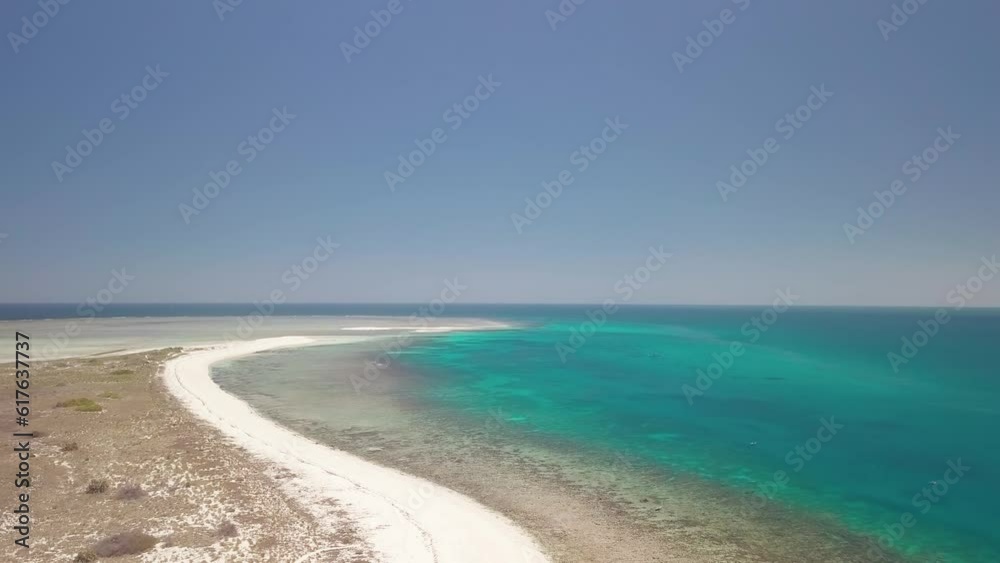 Bird s eye view of the turquoise waters surrounding the island of Nosy Ve in Madagascar. The crystal-clear water is visible, creating a beautiful contrast with the dark of the underwater reefs Bird s eye view of the turquoise waters surrounding the island of Nosy Ve in Madagascar. The crystal-clear water is visible, creating a beautiful contrast with the dark of the underwater reefs
