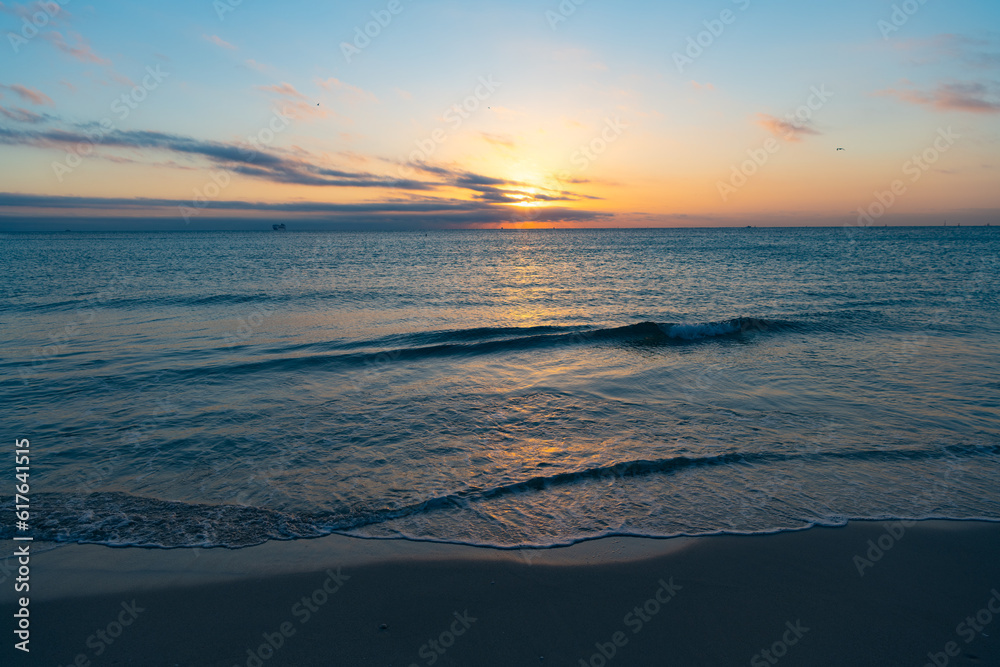 scenic sunset with sea water on the summer beach