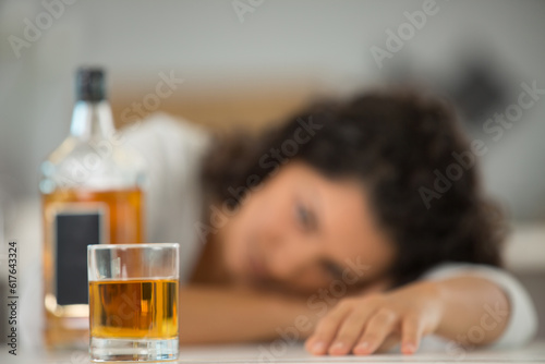 inebriated woman looking at a whisky bottle