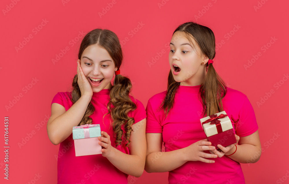 surprised children with present boxes on red background surprised children with present boxes on red background