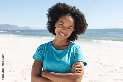 Portrait of happy african american woman looking at camera and smiling sunny on beach