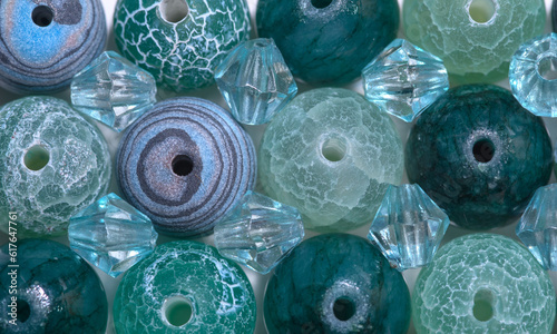 Niebiesko turkusowo zielona tapeta stworzona z barwnych, wzorzystych koralików do nawlekania, kamieni szlachetnych 