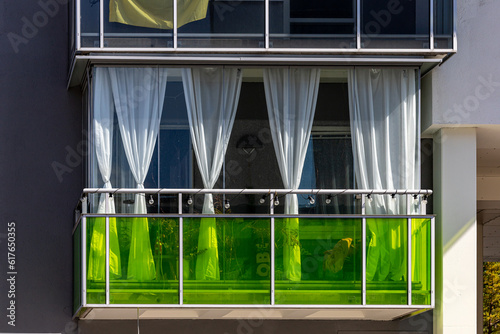 Photography Stockholm, Sweden A balcony in a residential building with green glass and curtains