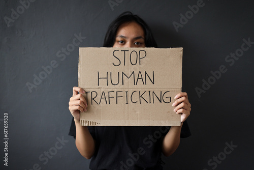 Stop Human Trafficking. Woman holding a board with Stop Human Trafficking text campaign. photo