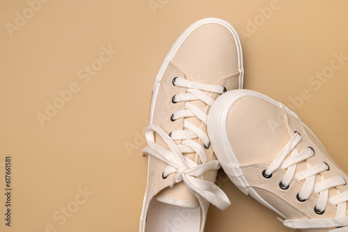 Papier peint Beige fabric sneakers on brown background flat lay top view