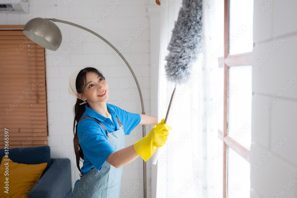 Asian young woman cleaning window in the living room. housework concept Asian young woman cleaning window in the living room. housework concept