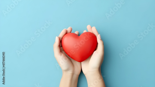 hand holding heart top view on blue background 