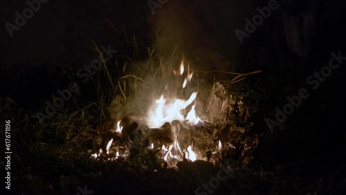 Fire burning garbage on outside at night