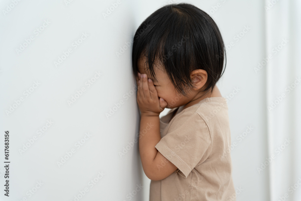 little asian children kid girl covering his eyes with hands, playing hide and seek standing next a wall house, Adorable child having fun in the home. happy family have fun with kids, activity little asian children kid girl covering his eyes with hands, playing hide and seek standing next a wall house, Adorable child having fun in the home. happy family have fun with kids, activity