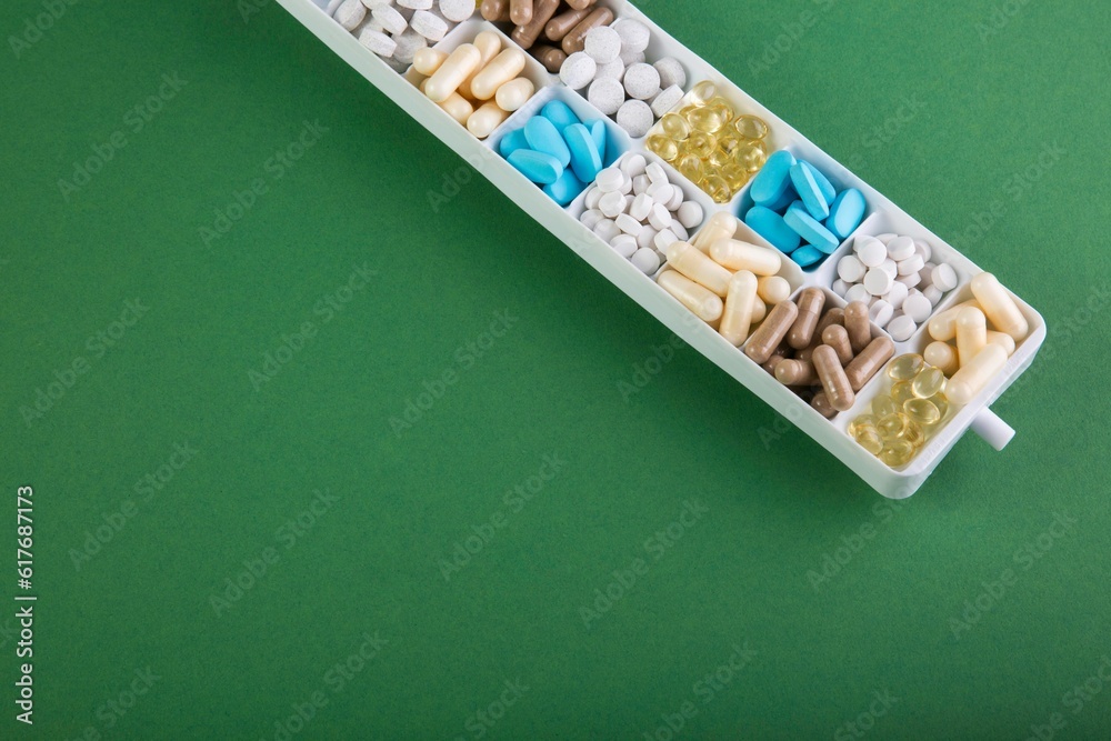 Box with different pills on a green background Box with different pills on a green background