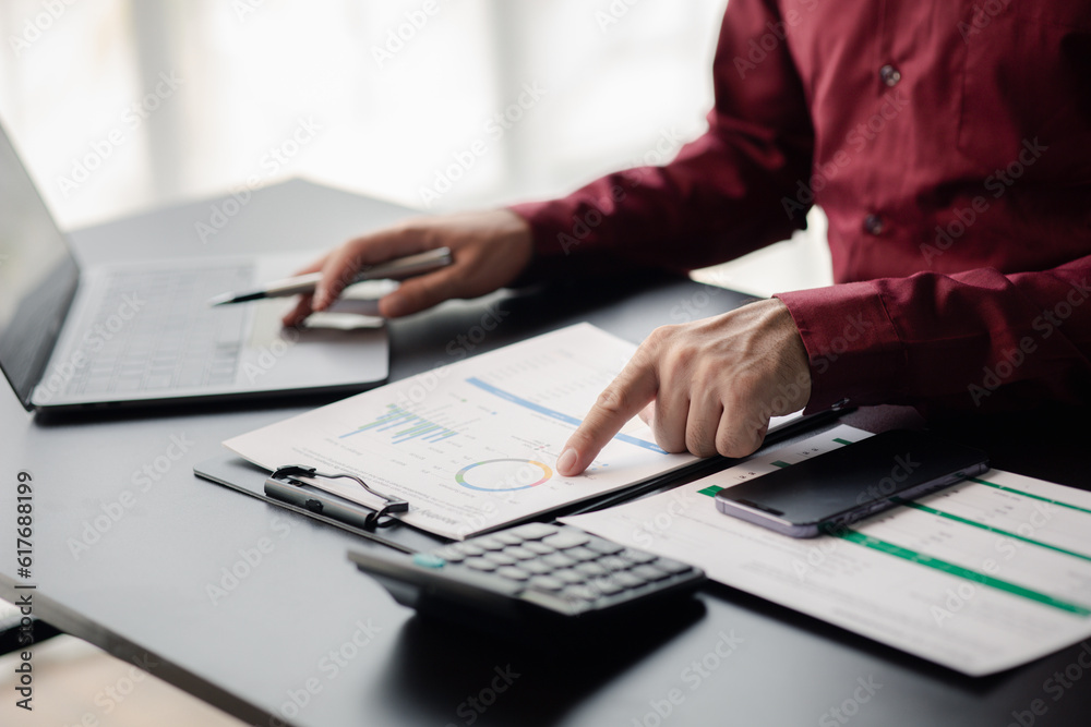 Business man checking financial documents, he owns a startup company, he sits checking the company's financial summary prepared by the finance department. Management concept of startup company.. Business man checking financial documents, he owns a startup company, he sits checking the company's financial summary prepared by the finance department. Management concept of startup company..
